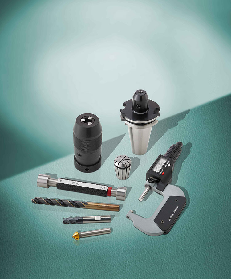 Katalogtitelbild verschiedener Messwerkzeugen und Fräswerkzeugen auf grünem Untergrund